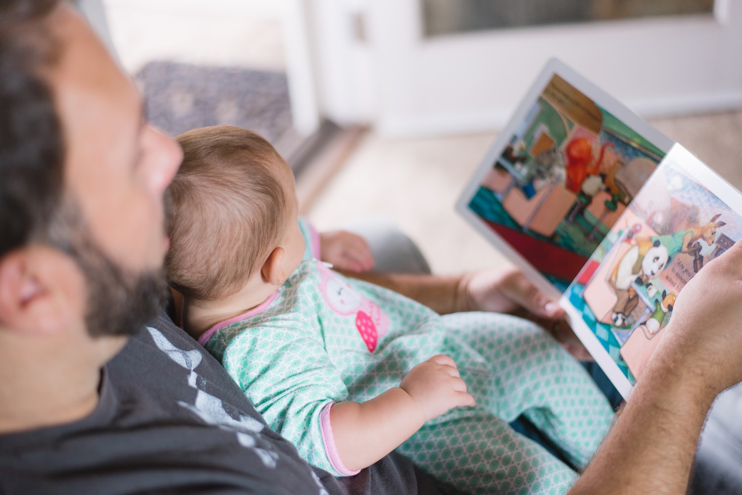 Vader leest prentenboek voor aan baby