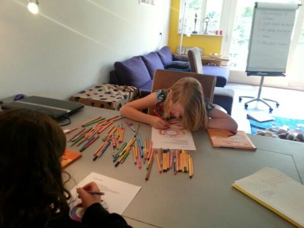 Twee kinderen kleuren tekening in aan grote tafel