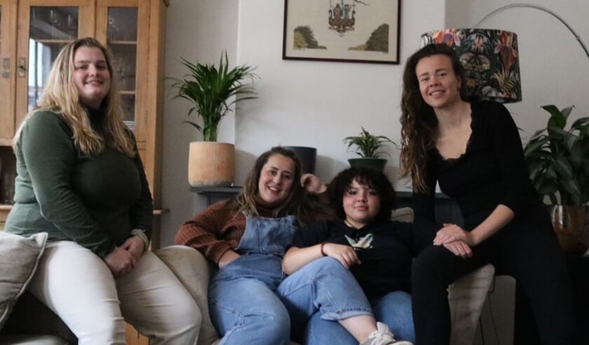 Vier jonge meiden op een bank in een huiskamer