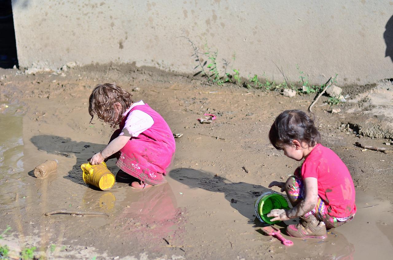 twee kinderen spelen in de modder