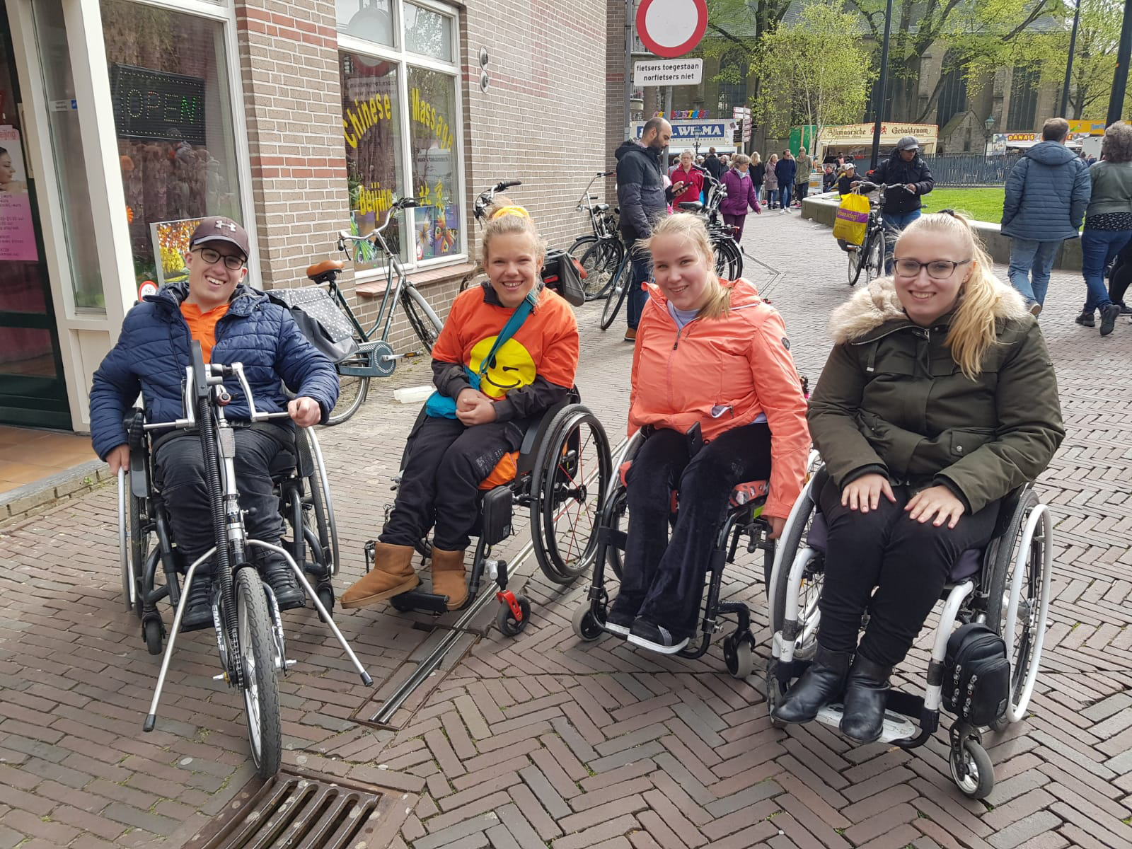 Foto van vier jongeren in een rolstoel