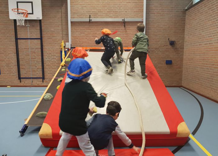 kinderen verkleed als Piet spelend in de sporthal
