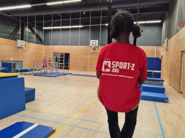 Foto van meisje met rood sportshirt in sportzaal