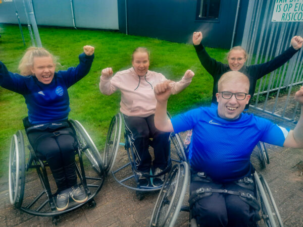 Vier mensen - kinderen en ouderen - in rolstoelen
