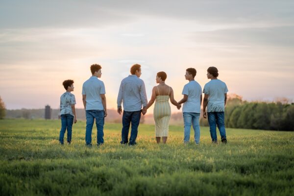 gezin met vier kinderen staan in een veld
