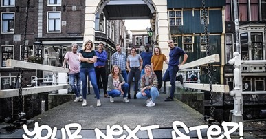 foto van 9 jongeren op een brug in stad
