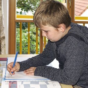 Jongetje in de klas schrijven in schrift