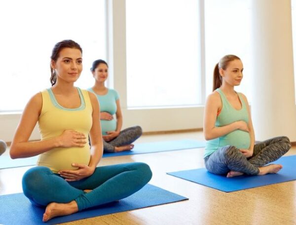 drie zwangere vrouwen op een gymmatje