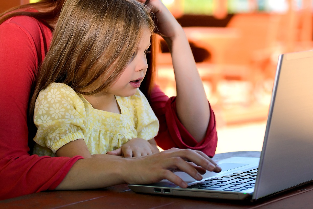 kind en moeder kijken op laptop