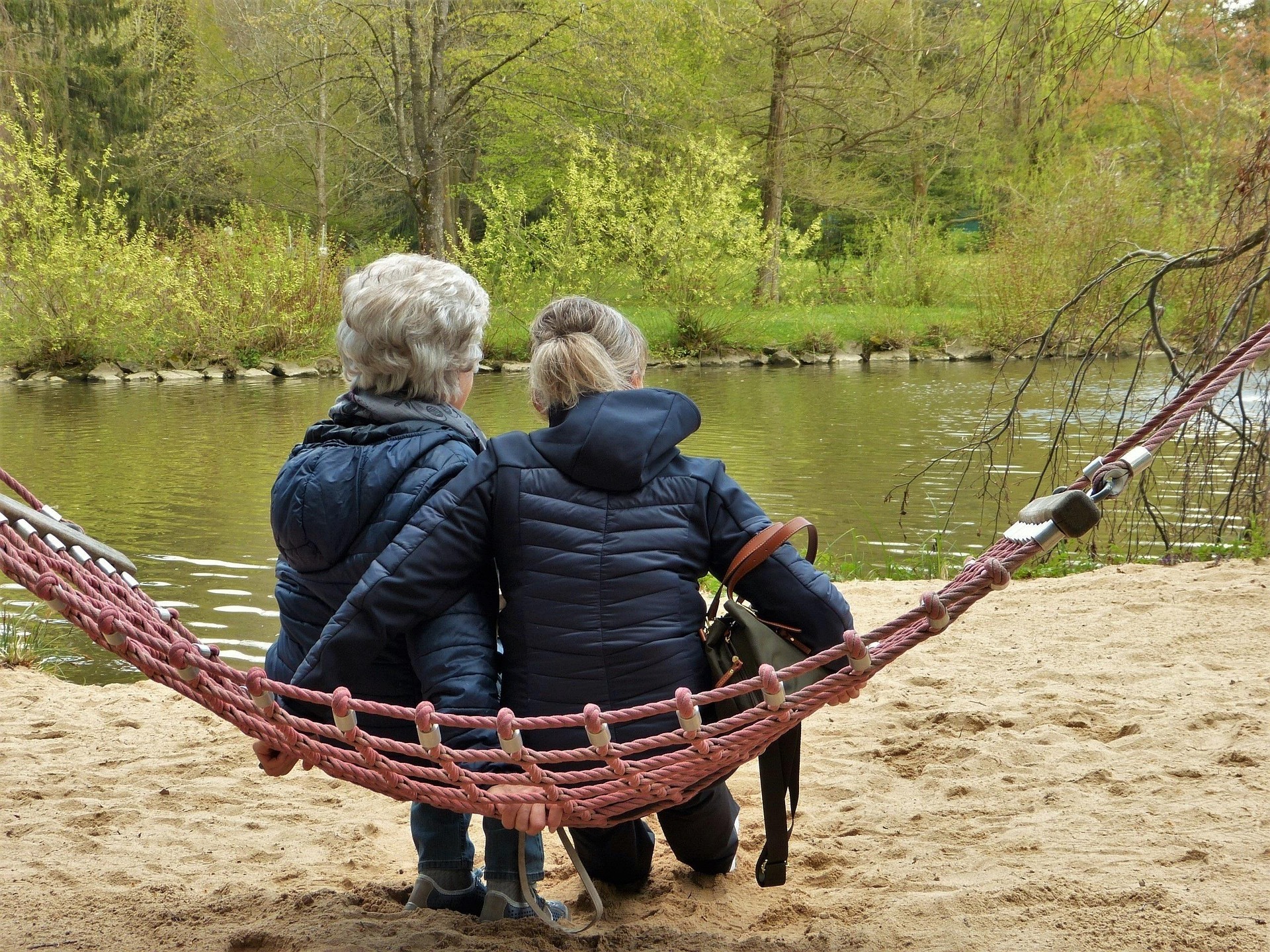 twee vrouwen waarvan de ruggen te zien zijn op een schommel