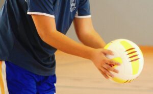 jongen in sportzaal die bal vasthoudt je ziet geen hoofd